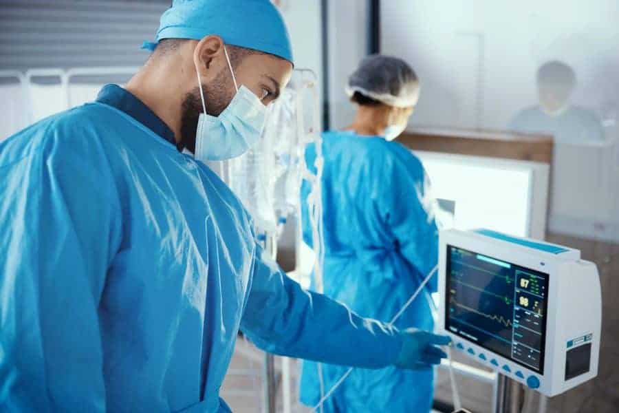 Advanced healthcare professionals monitoring patient vitals with medical devices in a hospital setting, emphasizing MedTech innovation and clinical excellence.