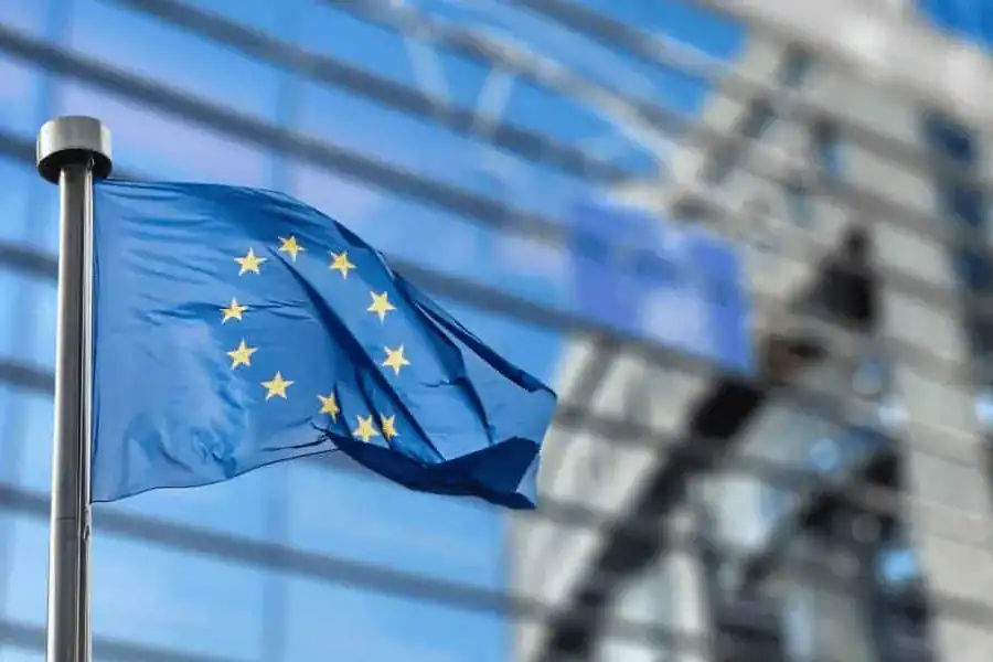 EU flag flying outside a modern building, symbolizing European medical technology standards and innovation.